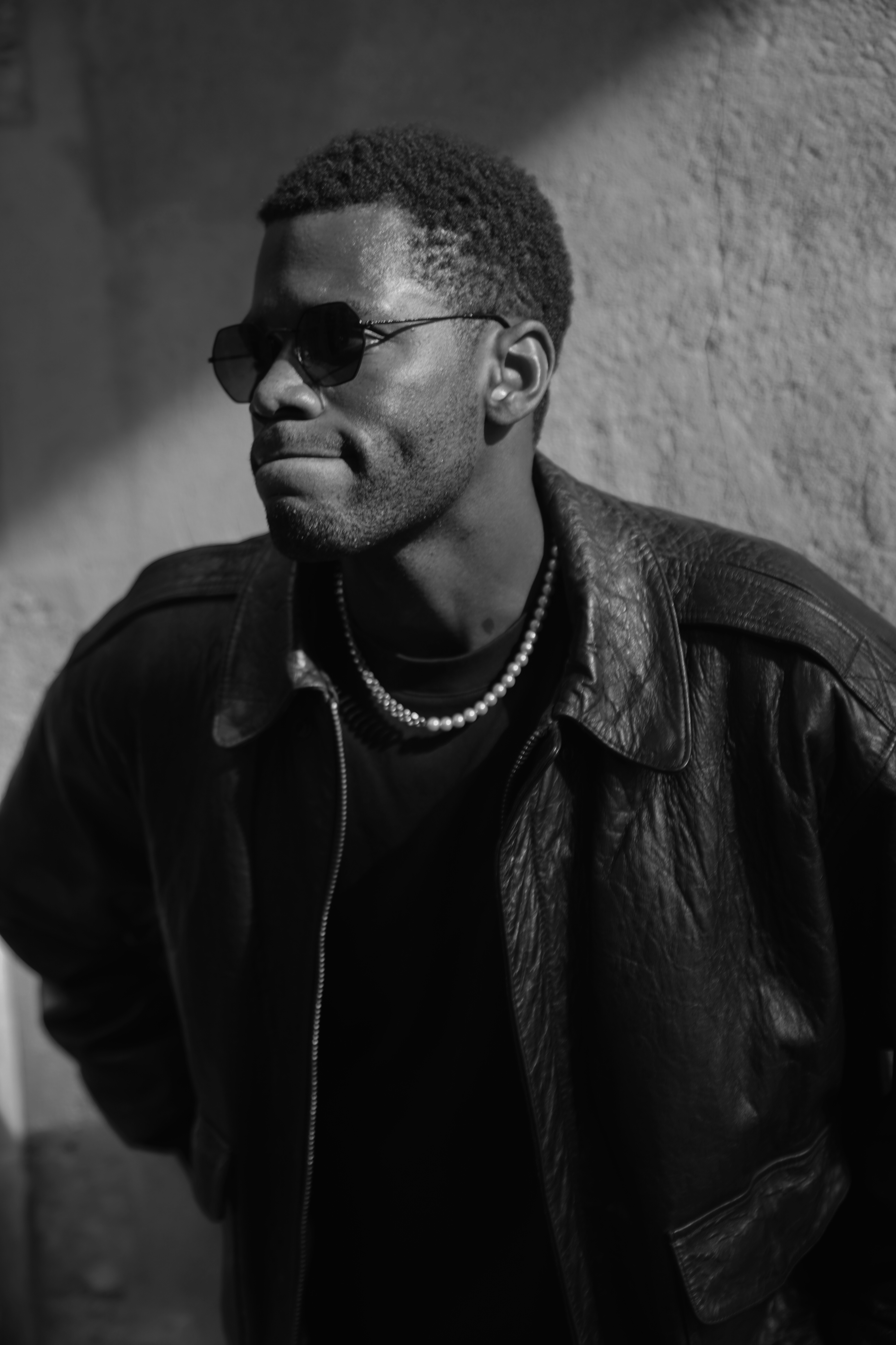 Man in leather jacket and sunglasses with silver chain necklace