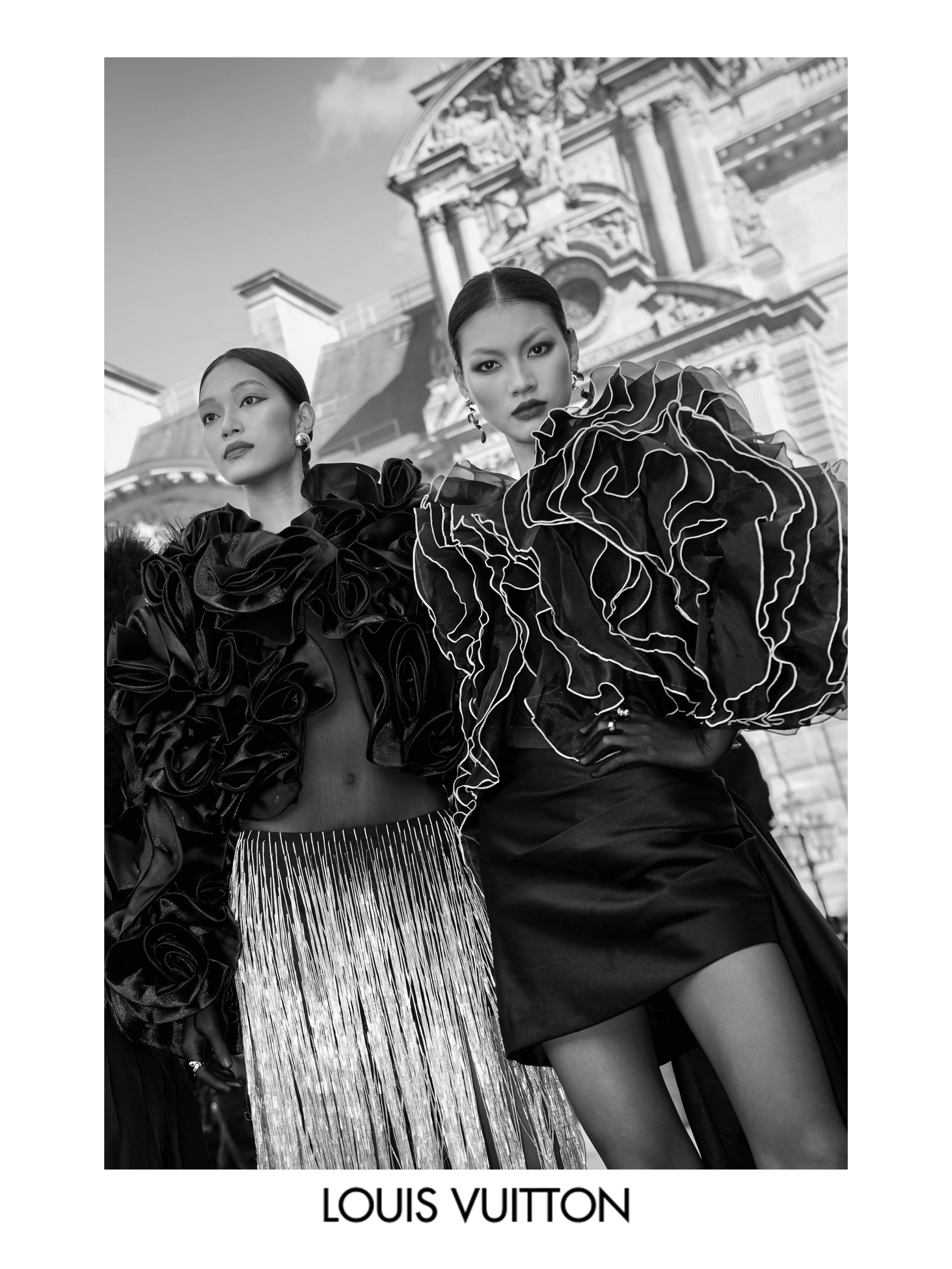 Louis Vuitton fashion photograph featuring two models in dramatic black haute couture with ruffled details